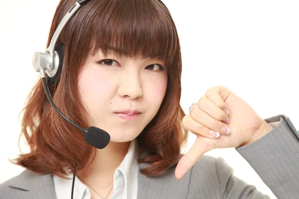 Jonge Japanse zakenvrouw van callcenter met hoofdreeksen met duimen omlaag gebaar — Stockfoto