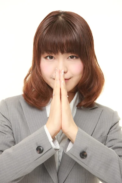 Young Japanese businesswoman folding her hands in prayer — Stock Photo, Image