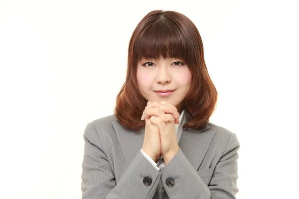 Young Japanese businesswoman folding her hands in prayer — Stock Photo, Image