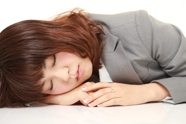 Joven mujer de negocios japonesa durmiendo en el escritorio —  Fotos de Stock