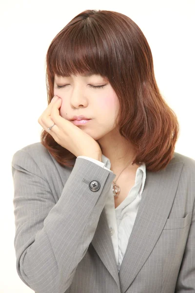 Joven japonesa mujer de negocios sufre de dolor de muelas — Foto de Stock