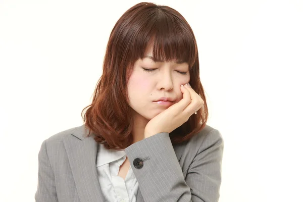 Young Japanese businesswoman suffers from toothache — Stock Photo, Image
