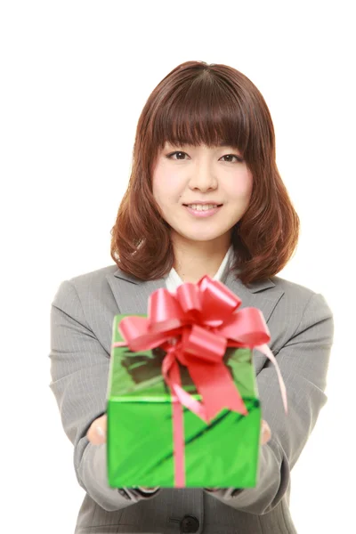 Jovem empresária japonesa oferecendo um presente — Fotografia de Stock