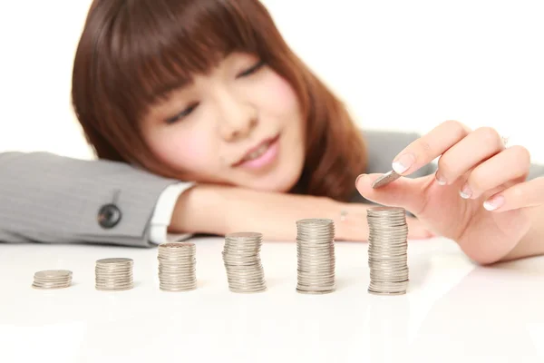 Businesswoman put coins to stack of coins — Stock Photo, Image