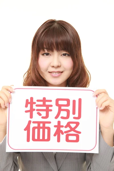 Businesswoman holding a message board with the phrase SPECIAL OFFER in KANJI — Stock Photo, Image