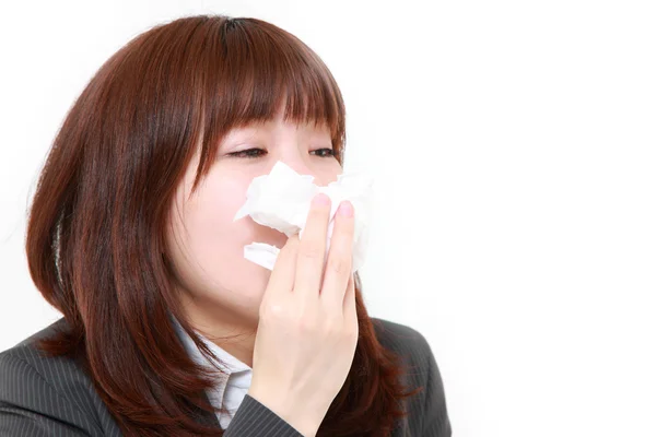 Businesswoman with an allergy sneezing into tissue — Stock Photo, Image