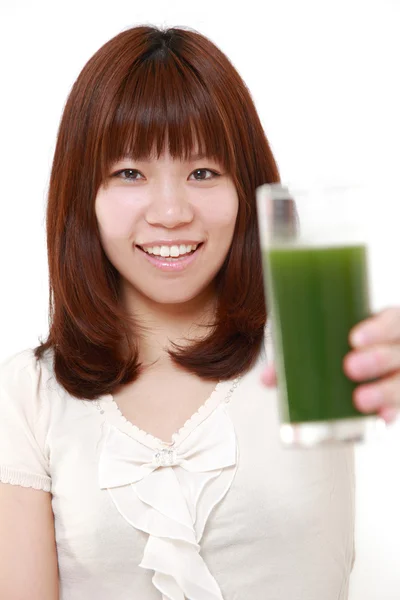 Mulher japonesa nova com suco vegetal verde — Fotografia de Stock