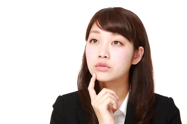 Joven japonesa mujer de negocios piensa en algo — Foto de Stock