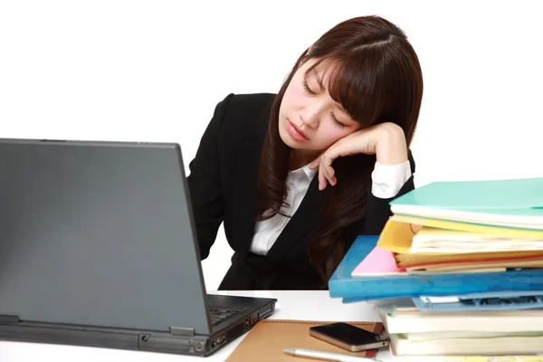 Junge japanische Geschäftsfrau schläft auf dem Schreibtisch — Stockfoto