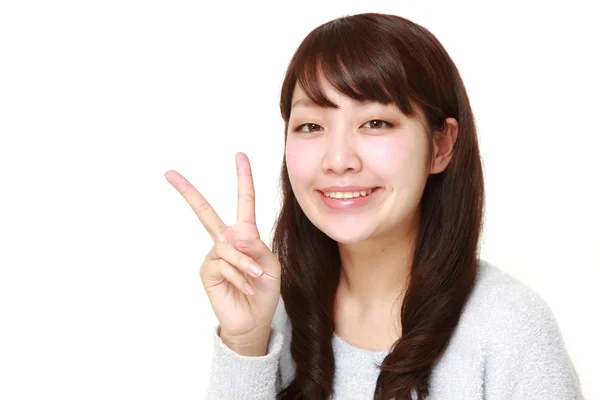 Mladá japonská žena ukazuje znak vítězství — Stock fotografie