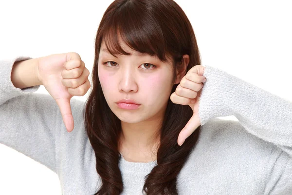 Jovem mulher japonesa com polegares para baixo gesto — Fotografia de Stock