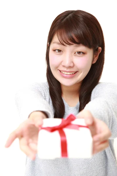 Młoda Japonka oferuje prezent — Zdjęcie stockowe