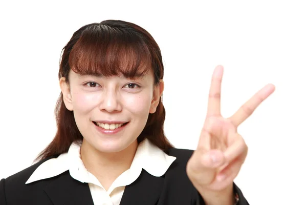 Aziatische zakenvrouw met een teken van de overwinning — Stockfoto