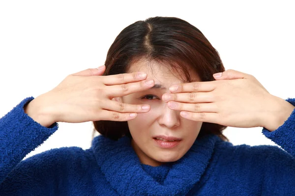 Woman covering her face with hands peeping at the camera through her fingers — Stock Photo, Image