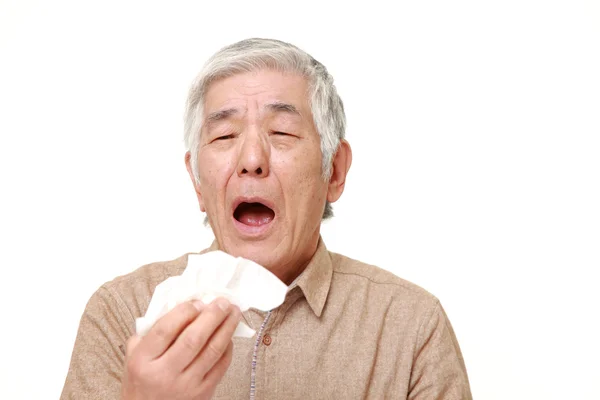 Senior Japanse man met een allergie niezen in weefsel — Stockfoto