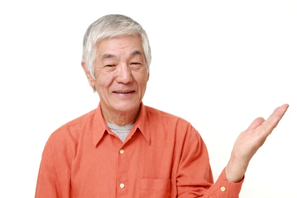 Sênior japonês homem apresentando e mostrando algo — Fotografia de Stock