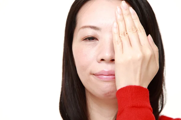 Японская женщина закрывает одним глазом руку — стоковое фото