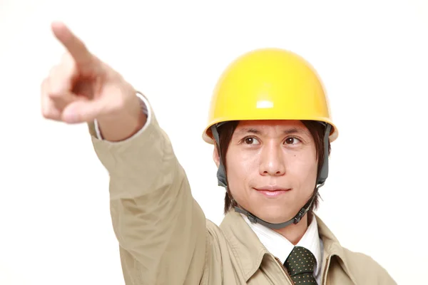 Joven trabajador de la construcción japonés apuntando hacia arriba — Foto de Stock