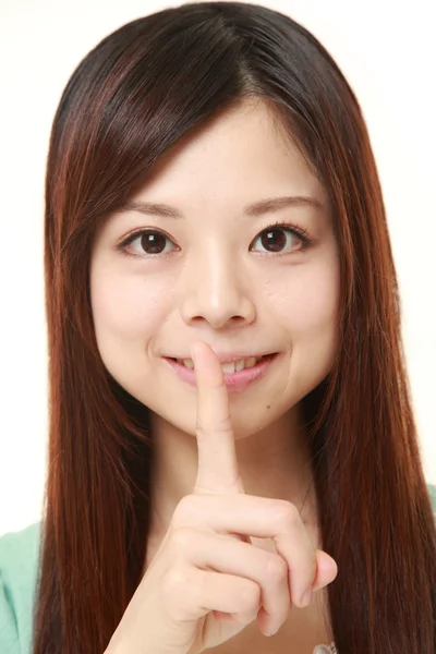 Unga japanska kvinnan whith tystnad gester — Stockfoto