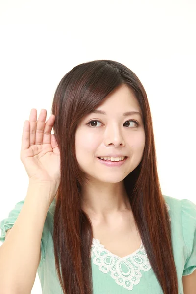 日本年轻女性用耳朵仔细听听后面一只手 — 图库照片