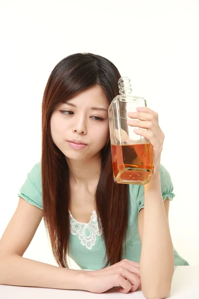 Young Japanese woman drinking straight from a bottle — Stock Photo, Image