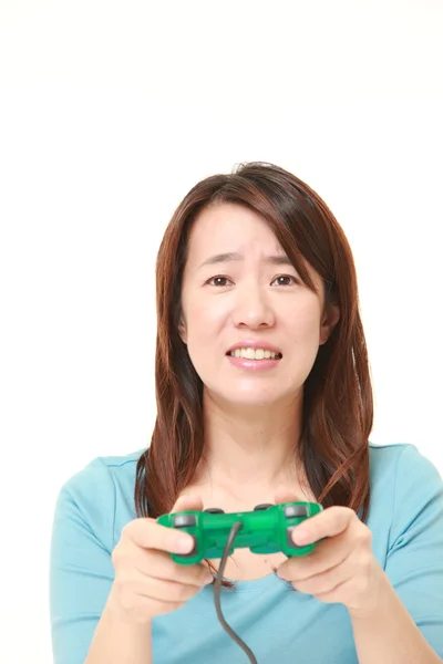 Middle aged Japanese woman losing playing video game — Stock Photo, Image