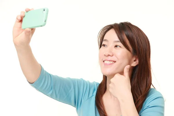 Japanische Frau mittleren Alters macht ein Selfie — Stockfoto