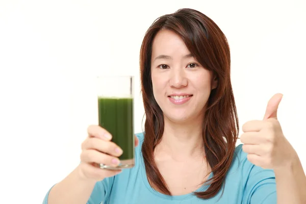 Middle aged Japanese woman with green vegetable juice — Stock Photo, Image
