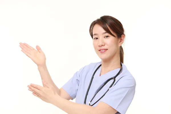 Japonaise médecin présentant et montrant quelque chose — Photo