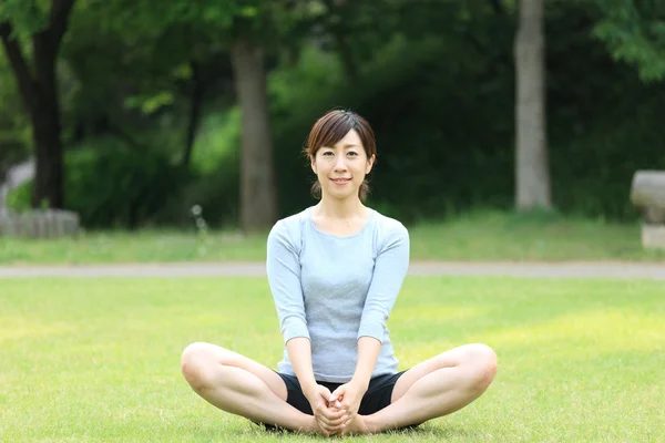 Japanese woman outside doing yoga — Stock Photo, Image