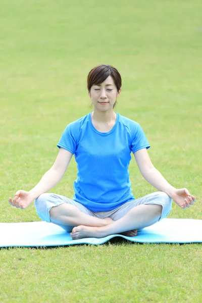 Japonesa mujer fuera haciendo meditación — Foto de Stock