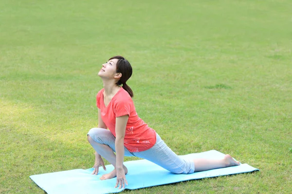 Japanerin draußen macht Yoga mit hohem Ausfallschritt — Stockfoto