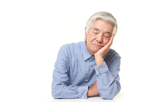 Старший японский мужчина спит на столе — стоковое фото