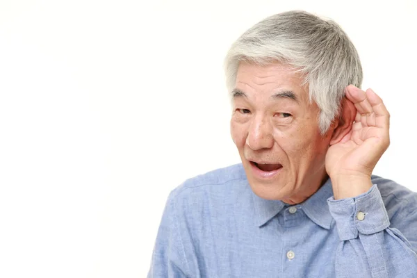 Sênior japonês homem com mão atrás da orelha ouvir de perto — Fotografia de Stock