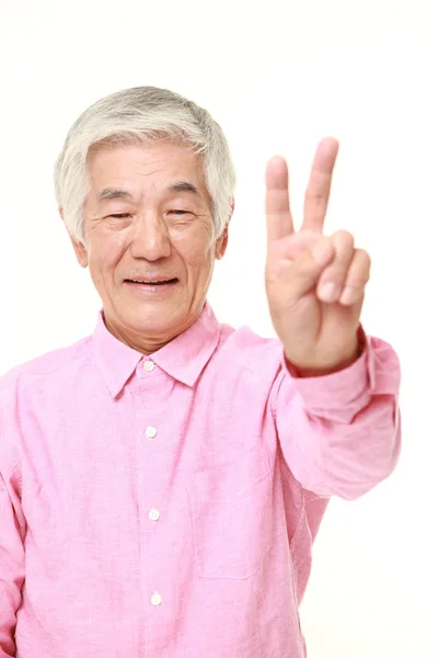 Старший японский мужчина показывает знак победы — стоковое фото