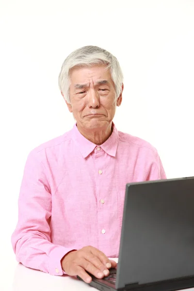 Sênior japonês homem usando computador olhando confuso — Fotografia de Stock