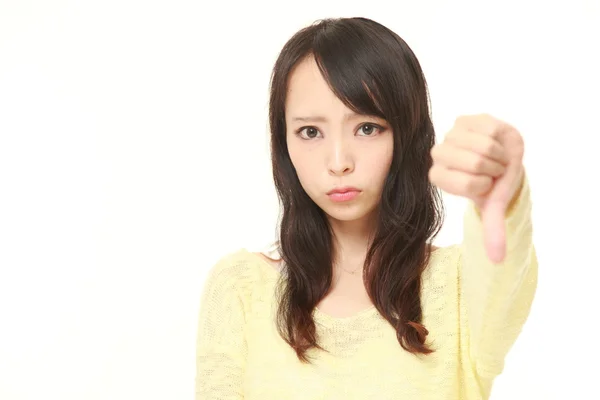 Młoda kobieta japoński z kciuk w dół gest — Zdjęcie stockowe