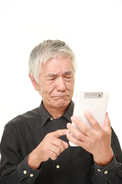 Senior Japanese man using tablet computer looking confused — Stock Photo, Image