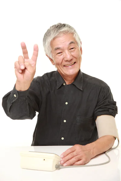 Starší japonský muž kontrola krevního tlaku — Stock fotografie