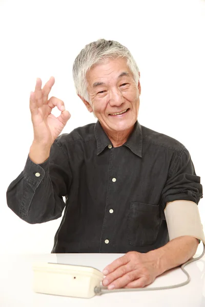 Sênior japonês homem verificando sua pressão arterial — Fotografia de Stock