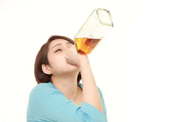 Junge Japanerin trinkt direkt aus einer Flasche — Stockfoto