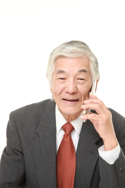 Старший бизнесмен беседует с классическим мобильным телефоном — стоковое фото