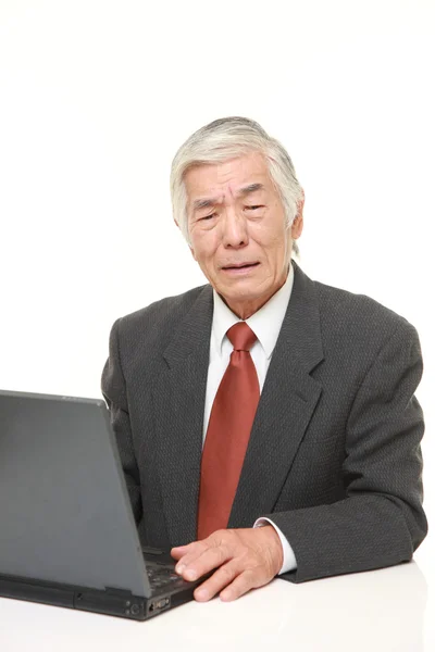 Senior japonés hombre de negocios utilizando ordenador buscando confundido —  Fotos de Stock