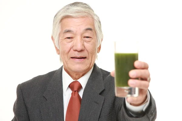Senior Japanese businessman with green vegetable juice — Stock Photo, Image