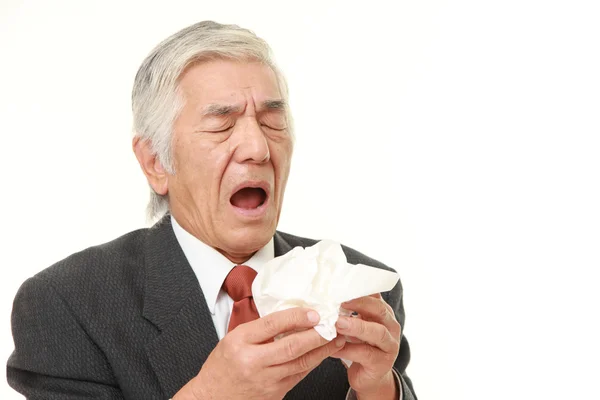 Japanischer Geschäftsmann mit einer Allergie, die ins Gewebe niest — Stockfoto