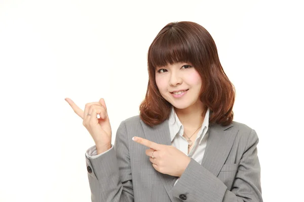 Tânără femeie de afaceri japoneză prezentând și arătând ceva — Fotografie, imagine de stoc