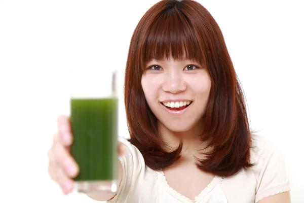 Mulher japonesa nova com suco vegetal verde — Fotografia de Stock