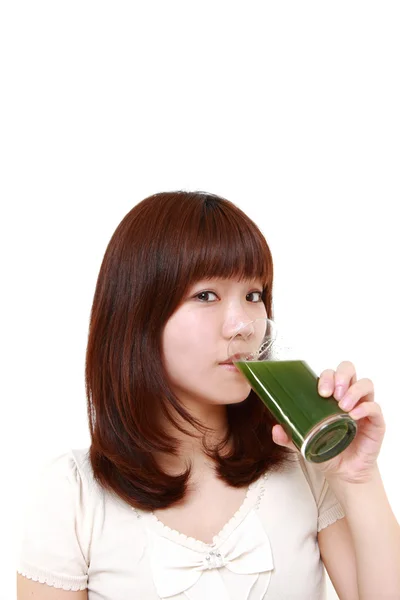 Mulher japonesa nova com suco vegetal verde — Fotografia de Stock