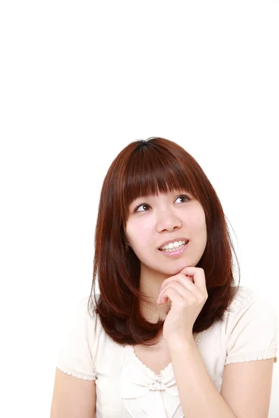 Jovem mulher japonesa pensa em algo — Fotografia de Stock