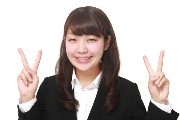 Jovem empresária japonesa mostrando um sinal de vitória — Fotografia de Stock